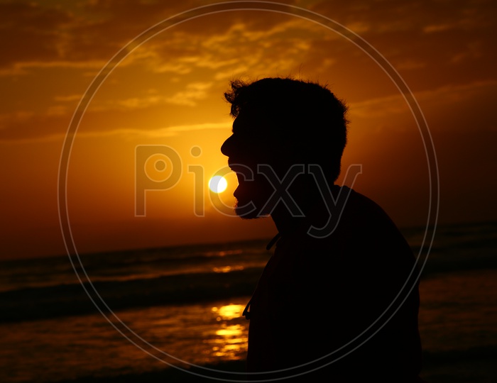 Silhouette Of a  Man Yelling Over a Sunset Sky