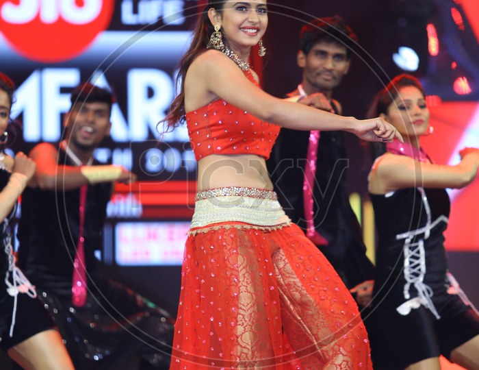 Tollywood Movie Actress Rakul Preet dancing wearing a red dress on stage