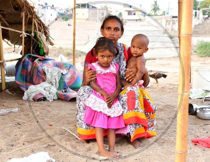 Indian Migratory Family Mother Along With Their Children At a Hut Made Of Plastic banners
