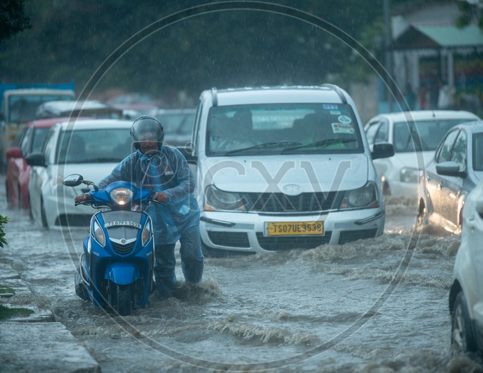A Bike Commuter Taking Her Bike In Flooded Hyderabad City Roads Due To Heavy Rainfall