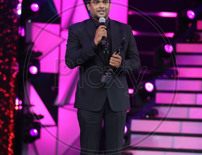 Actor Madhavan holding his filmfare award on the stage