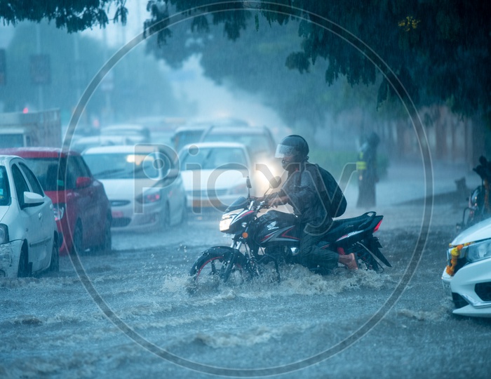 A Bike Commuter Riding In Flooded Road in Heavy Rain