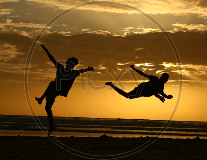 Silhouette Of a Man Doing Gymnastics In a Beach With Sunset Golden Sky In Background  At Goa