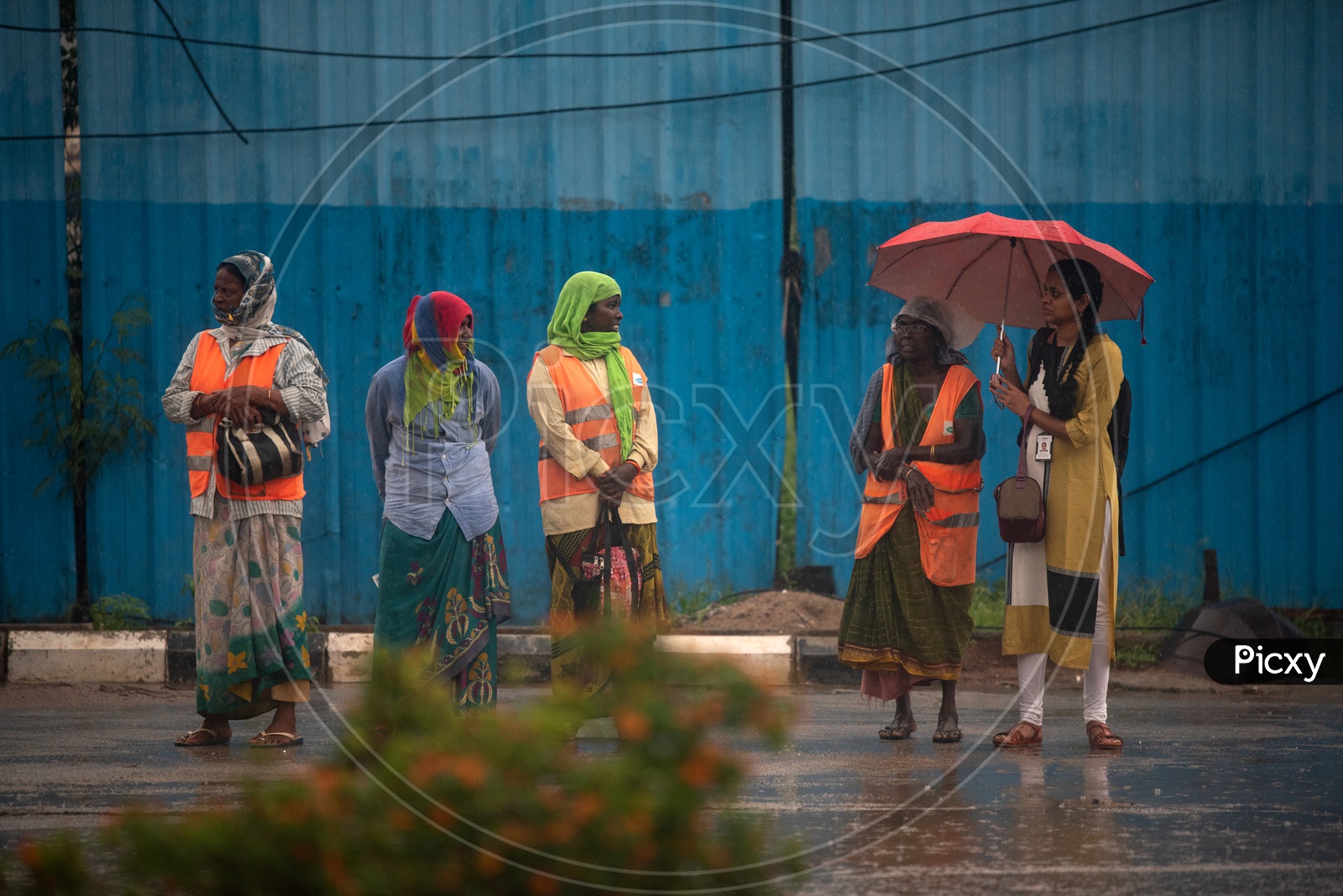 Women waiting for a Bus while raining