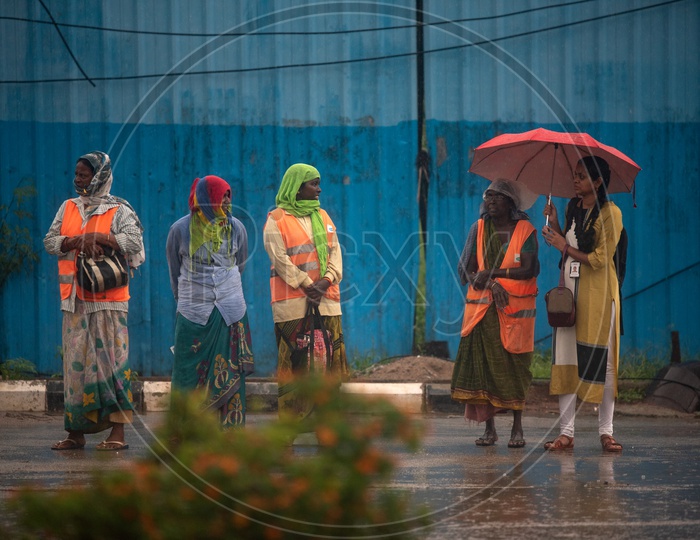 Women waiting for a Bus while raining