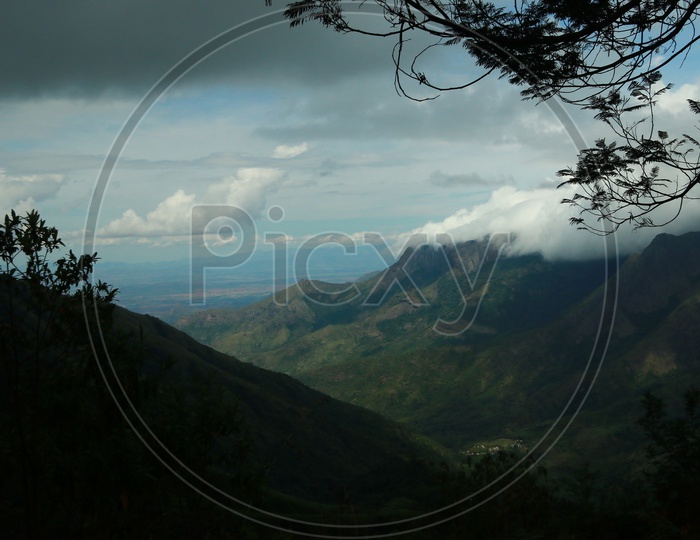 A Landscape of  Green mountains With Valleys And Fog Clouds Over Mountains  In Munnar