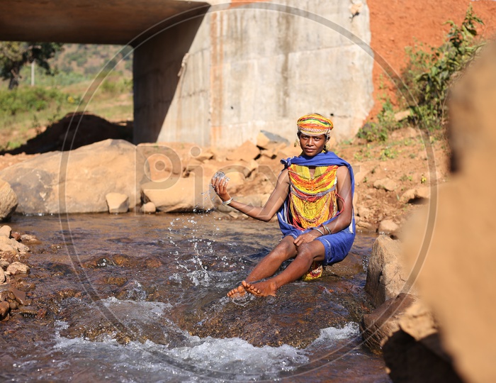 Bonda Tribal Woman Playing With Water At a Water Flowing Channel in a Tribal Village