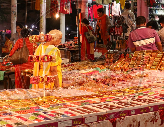 An old woman shopping for bangles at a stall
