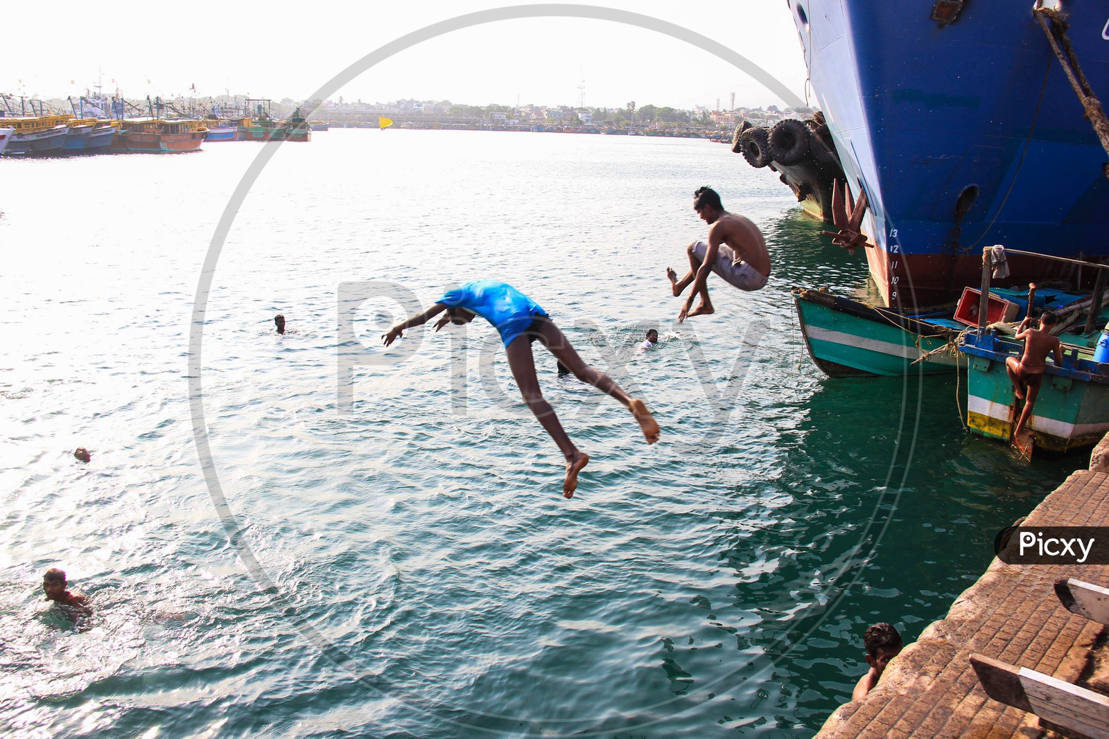 Children jumping off boats into the sea at the port of Vizag.