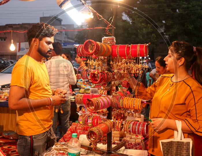 Indian Woman Purchasing Bangles From a Merchant At A Road Side Stall