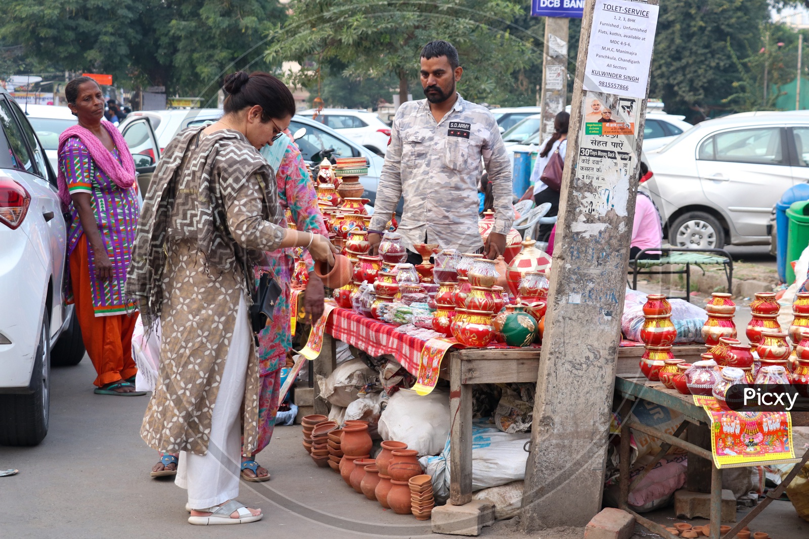 Indian Woman Purchasing Pots From a Roadside Vendor Stall