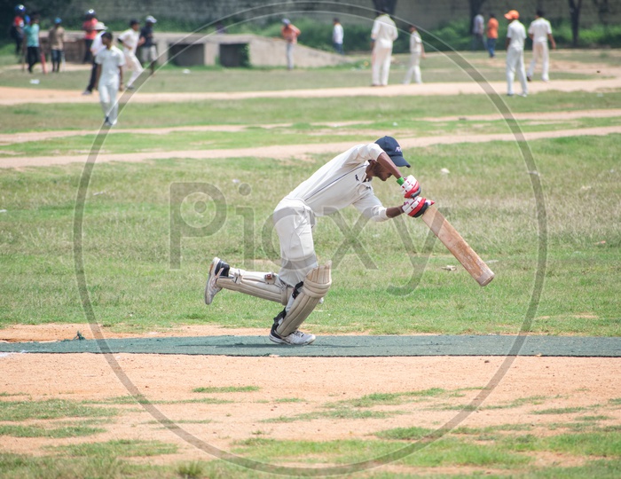 Cricket batsman hitting the ball, in action