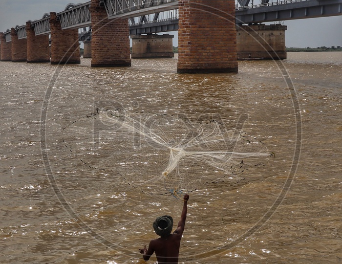 A fisherman throwing his net  on River godavari