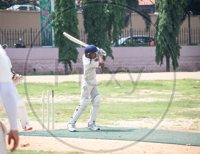 A cricket batsman batting in the ground