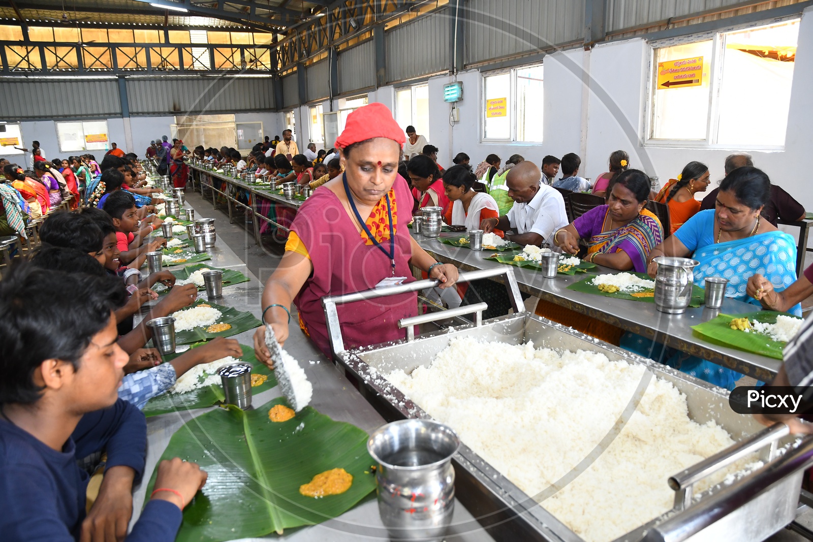 Volunteer Serving Food to Devotees in a Temple
