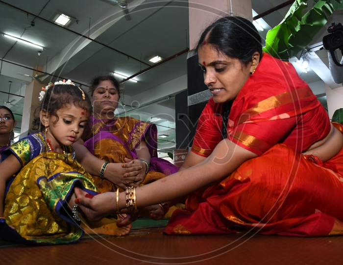 An Indian Hindu woman applying turmeric paste onto Girl feet prior to performing prayers to the Hindu Goddess Kanaka Durga