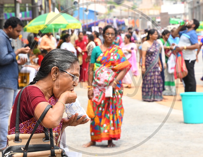 A Old Woman eating Prasadam outside temple