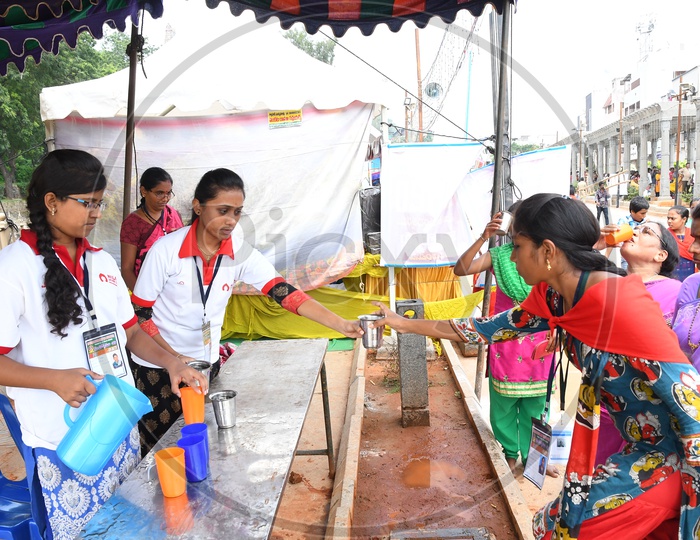 Female Volunteers Distributing Water to Devotees