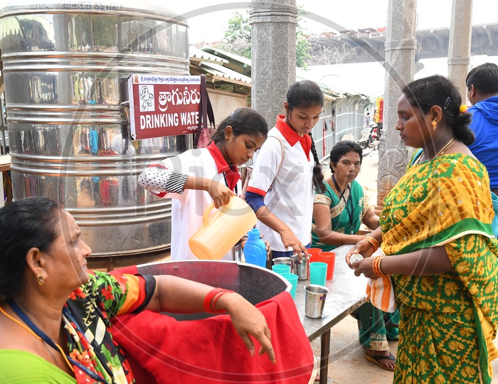 Female Volunteers Distributing Water to Devotees