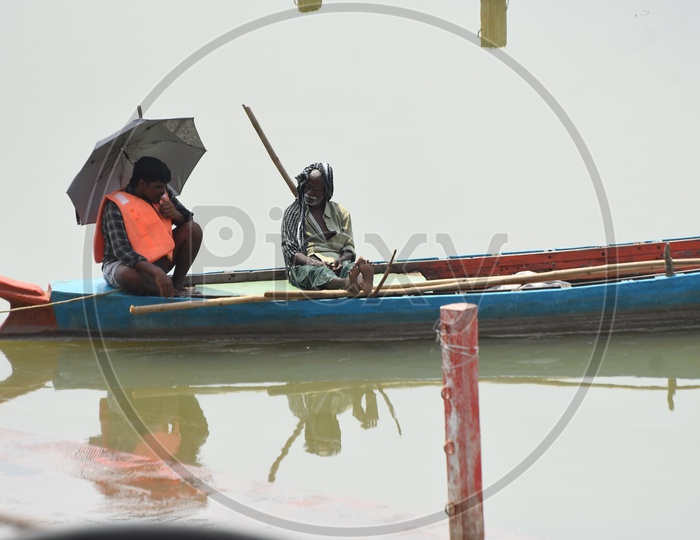 Boat Man Sitting on Boat At Krishna River Ghats In Vijayawada