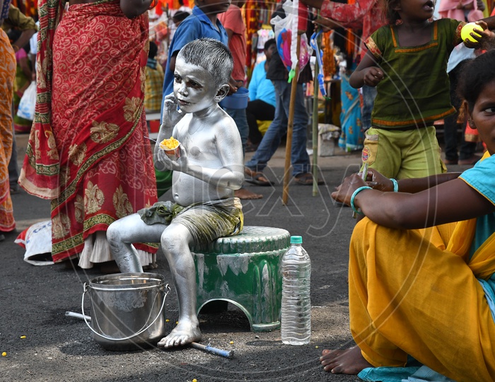 Indian Boy or Street Artist  As Mahatma Gandhi Getup And Painted in Silver Begging on Streets of Vijayawada During  Durga Navratri Festival