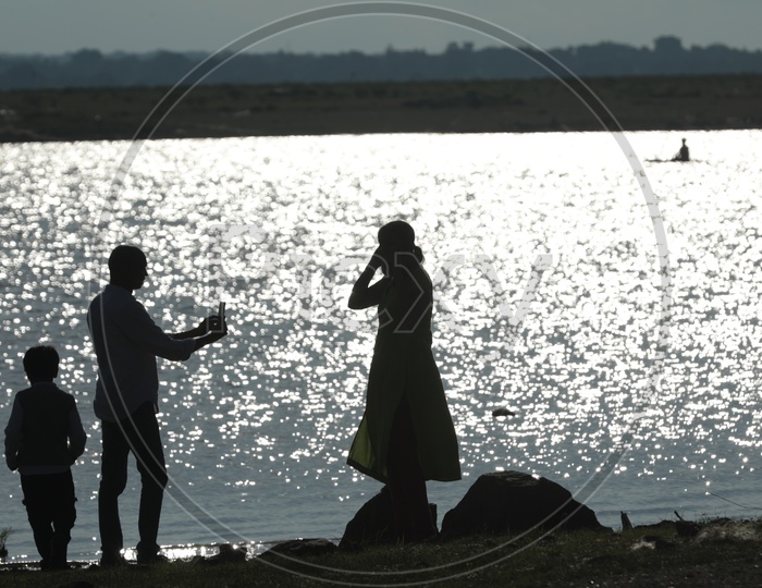 Indian Man taking pictures of her Wife by the lake