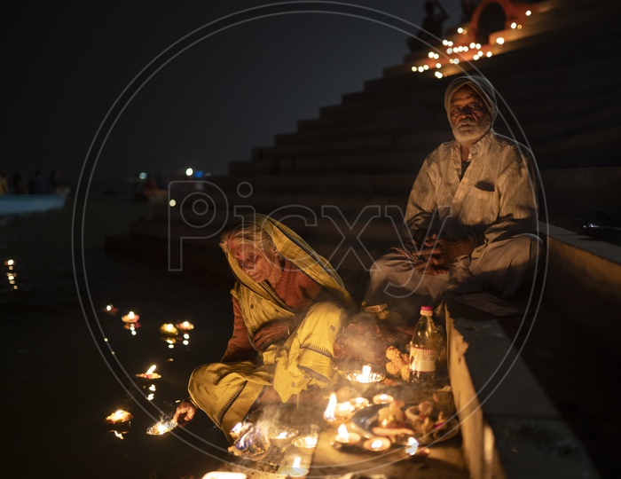 An elderly couple worshiping during Dev Diwali
