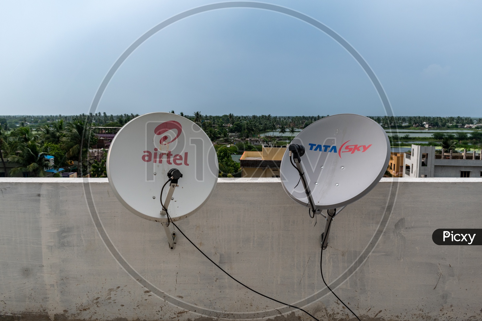 Airtel DTH dish and Tata Sky DTH dish installed on the terrace of a building.