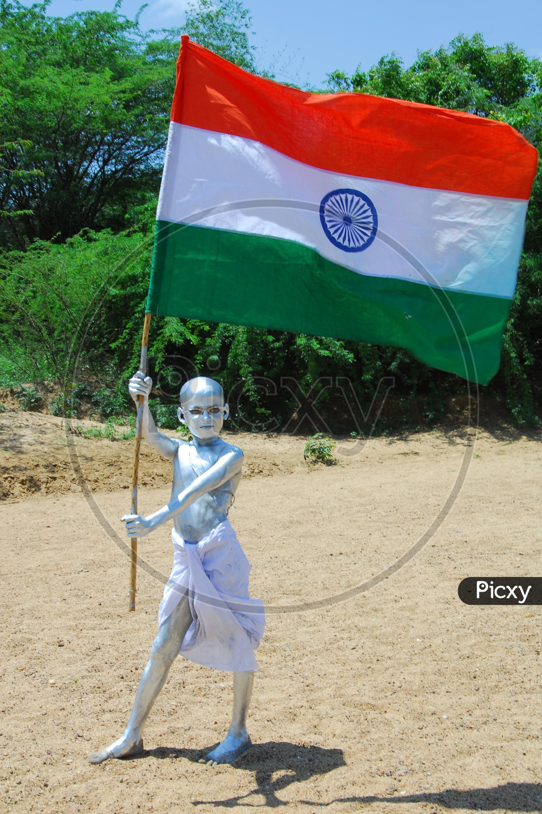 Indian Kid with Silver Paint as Gandhi holding an Indian Flag