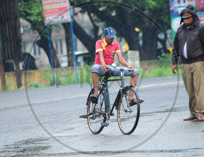 An Indian Kid riding bicycle during rain