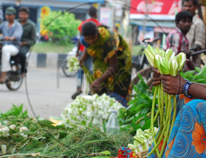 Indian Woman selling flowers by the road