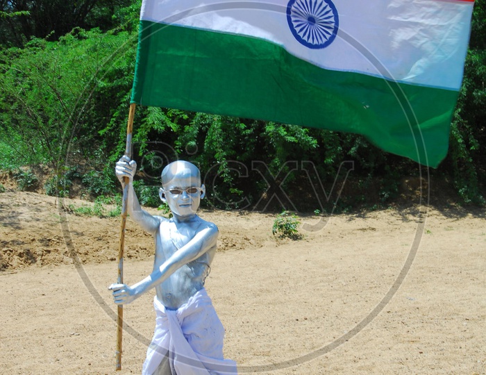 Indian Kid with Silver Paint as Gandhi holding an Indian Flag