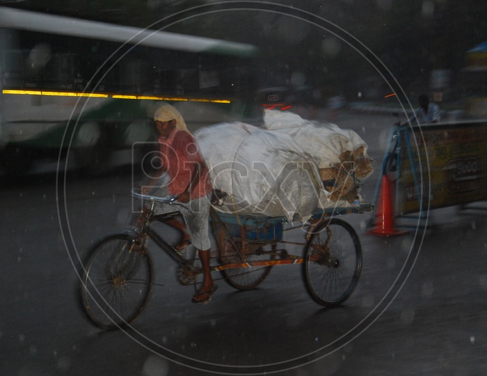 Indian boy riding rickshaw during heavy rain