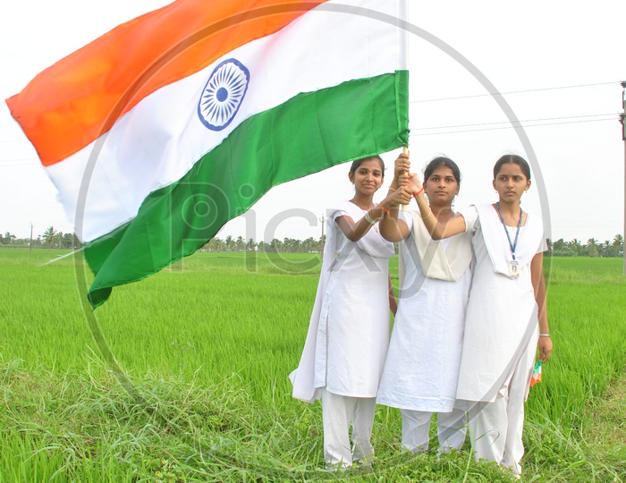 Indian College Students holding Indian Flag in the green fields