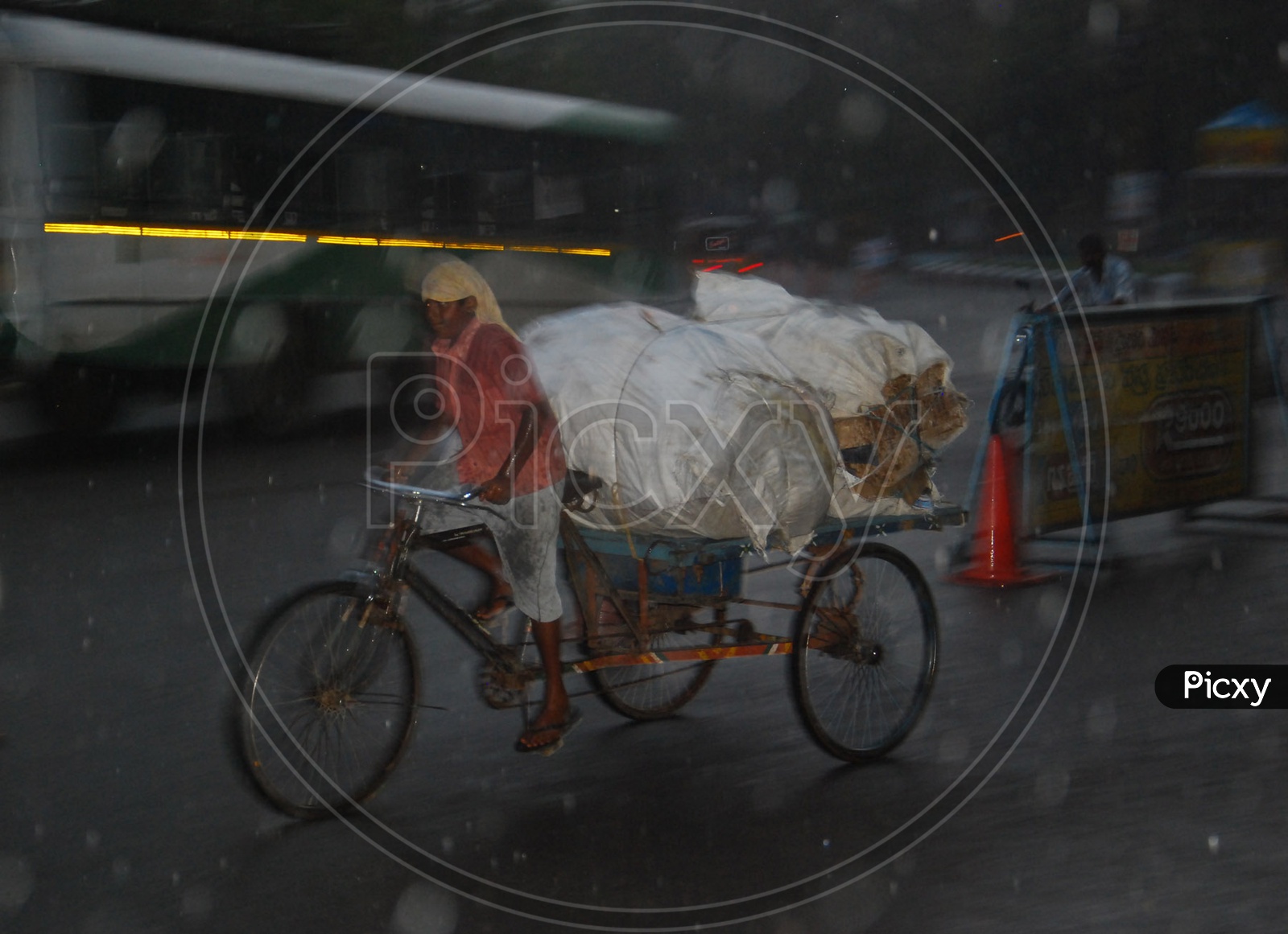 Indian boy riding rickshaw during heavy rain