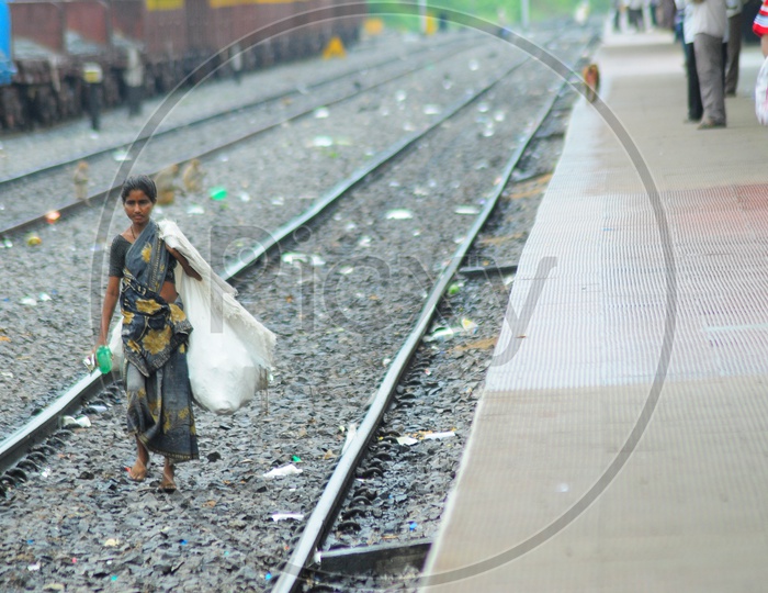 A Female Rag picker walking on the railway track