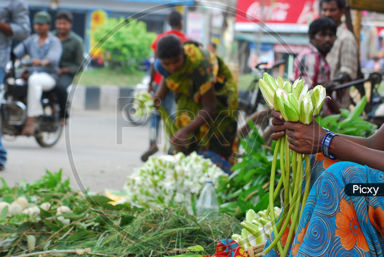 Indian Woman selling flowers by the road