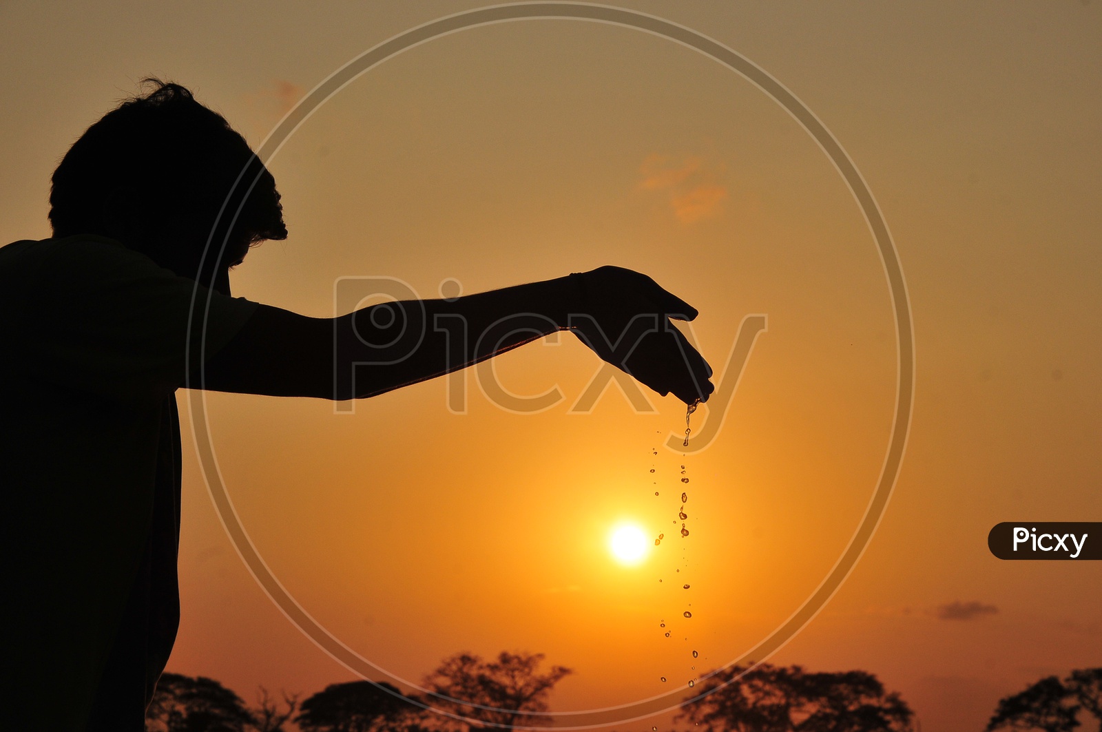 Silhouette of a man leaving water from hand