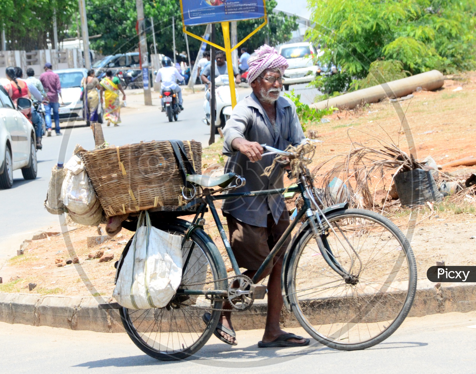 Image of Indian Old Man carrying a basket on the bicycle OC931987