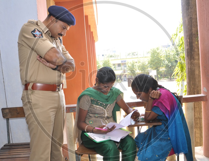 A Police Man spectating Students writing exam
