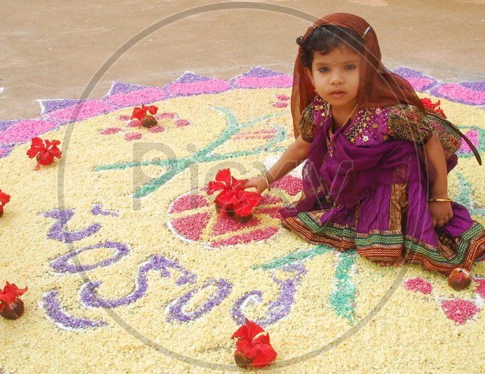A Little girl sitting on the Rangoli during Pongal