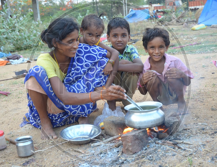 An Indian Rural Mother cooking food for their children