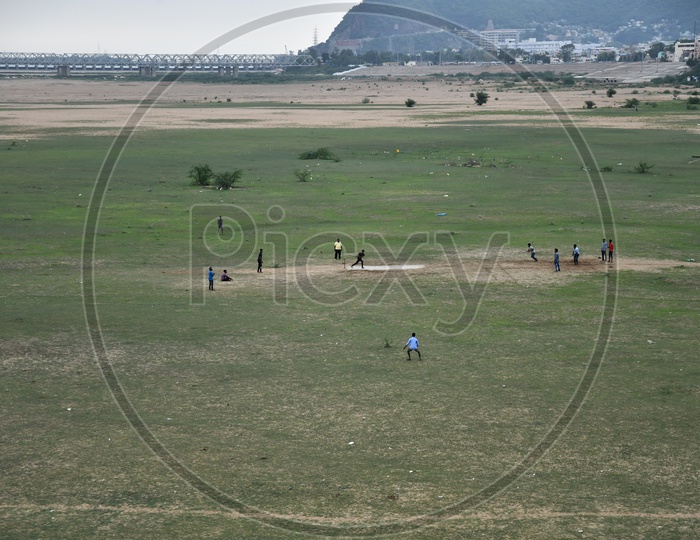 Unidentified People Playing Cricket on Sand at Vijayawada