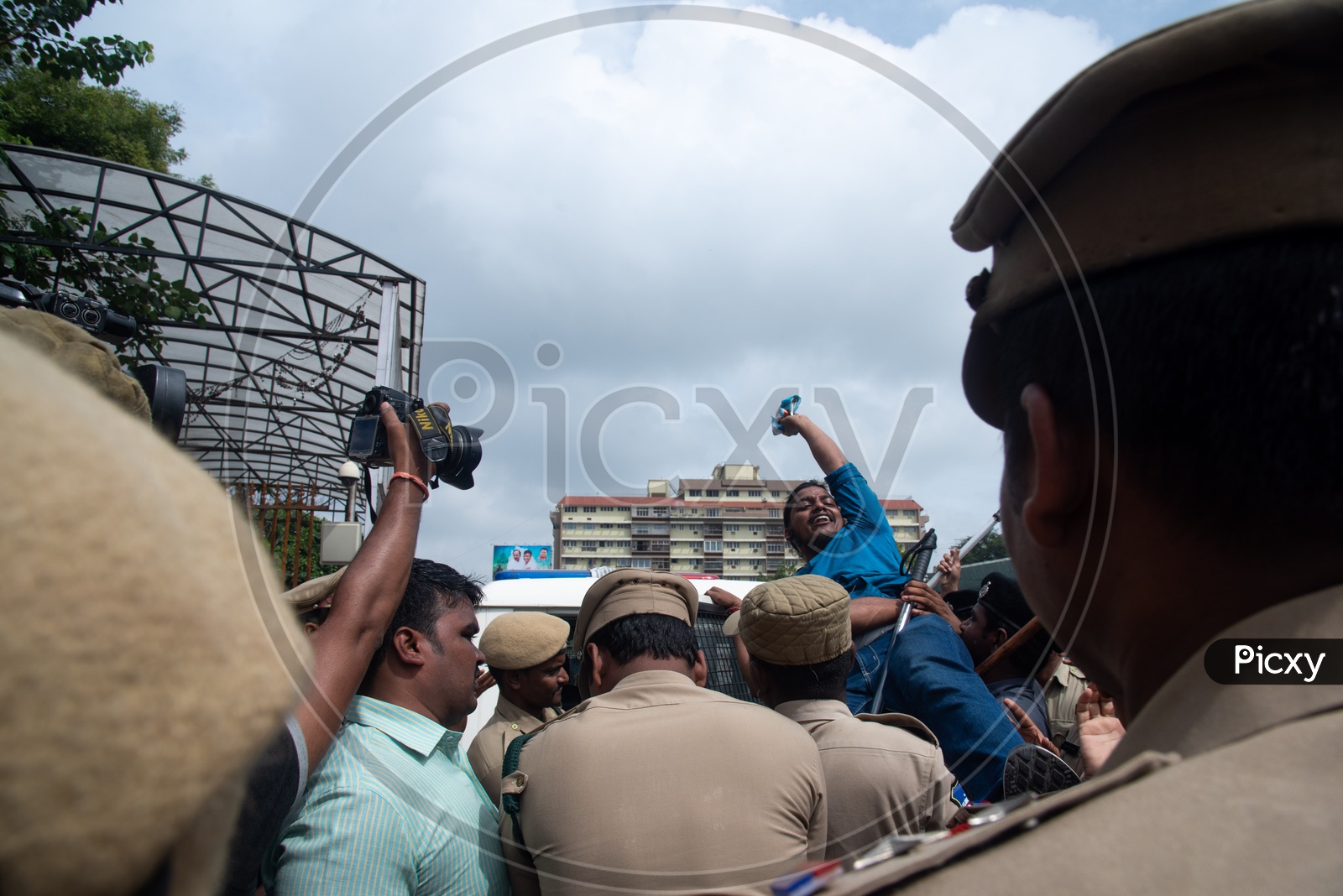 A man being detained into a vehicle by Telangana Police as he protests at Pragathi Bhawan Gherao