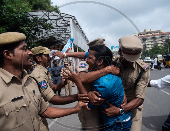 A man being detained by Telangana Police as he protests at Pragathi Bhawan Gherao