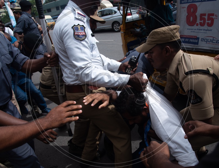 A man being detained  by Telangana Police as he protests at Pragathi Bhawan Gherao