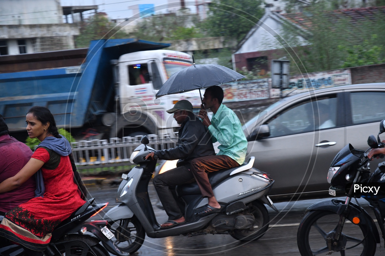 Unidentified Men on Two Wheeler without Helmet driving in Rain