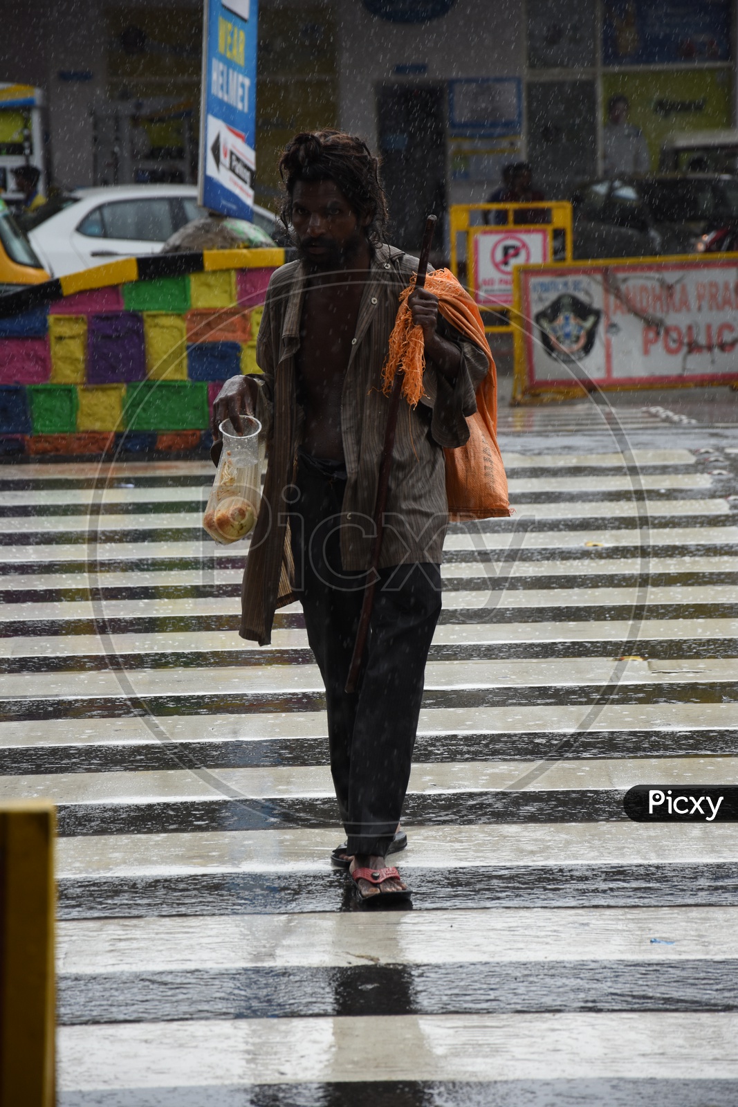 A Beggar walking on Road while Raining