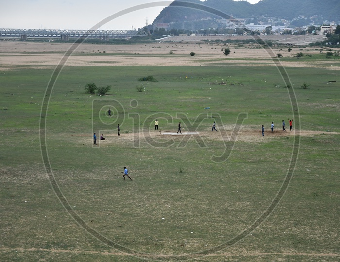 People Playing Cricket on Sand in Krishna River