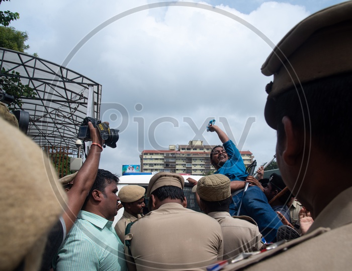 A man being detained into a vehicle by Telangana Police as he protests at Pragathi Bhawan Gherao